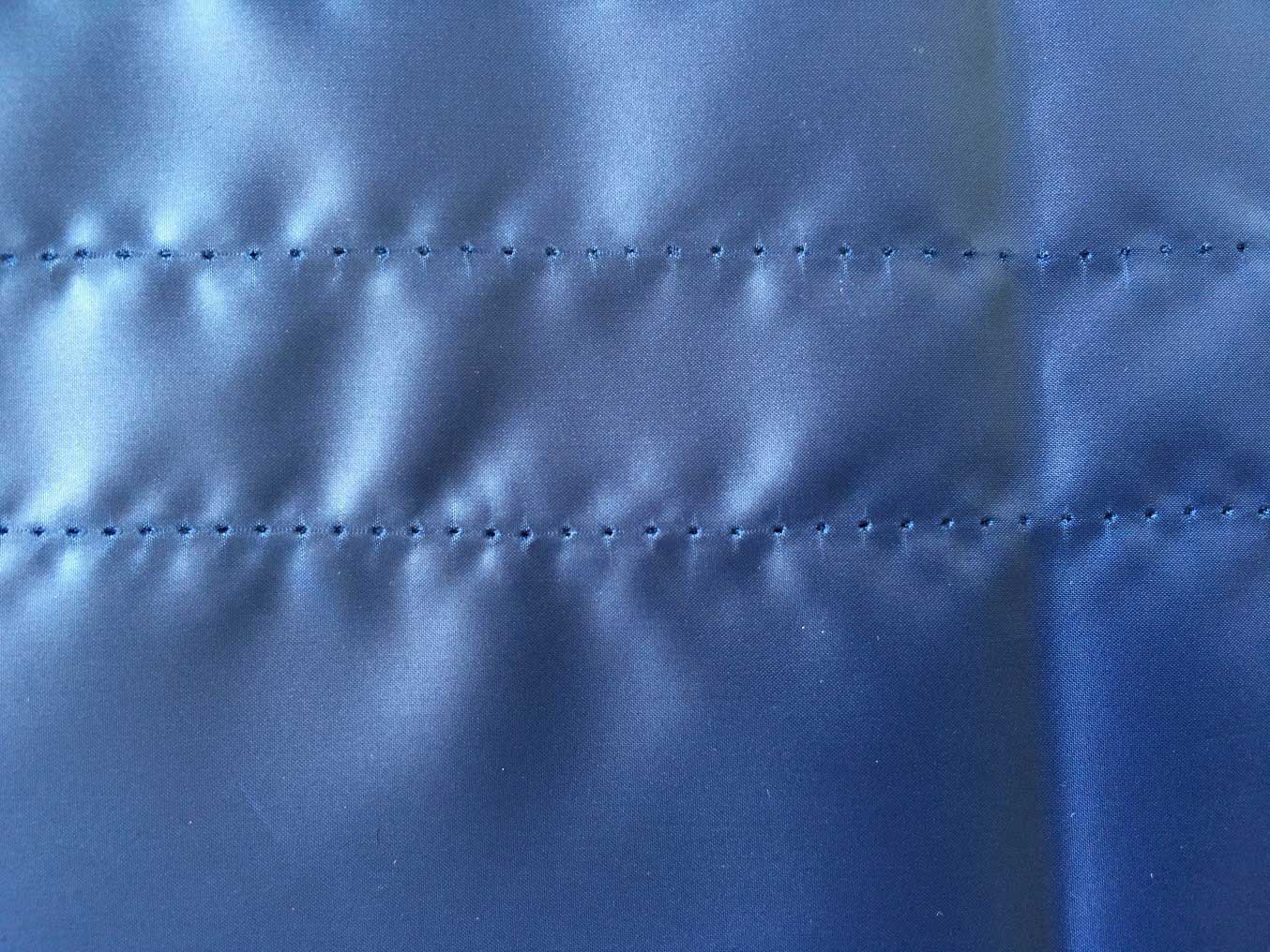 Displacement puckering stitch holes